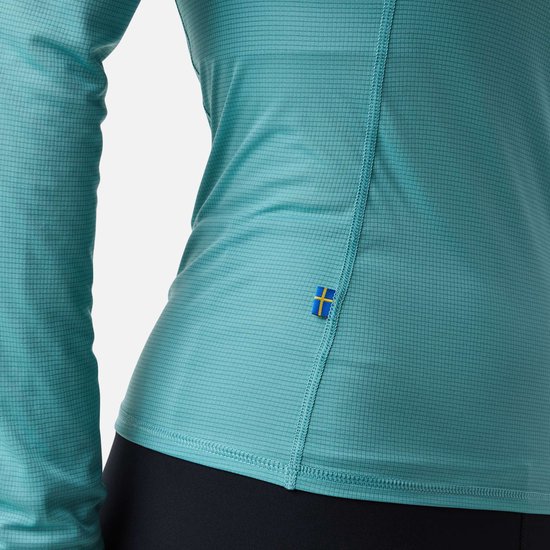 Detail van turquoise sportshirt, met Zweedse vlag patch.
