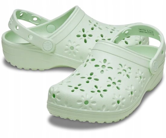 Paire de sabots Crocs vert pâle, vue de côté, avec perforations florales.