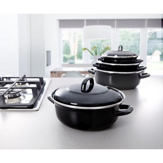 Zwarte braadpan op aanrecht met stapel pannen.