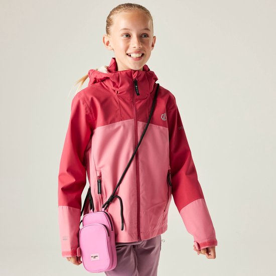 Meisje in een roze en fuchsia Dare2B jas met capuchon, een lichtroze telefoonhoesje om haar nek en paarse broek.
