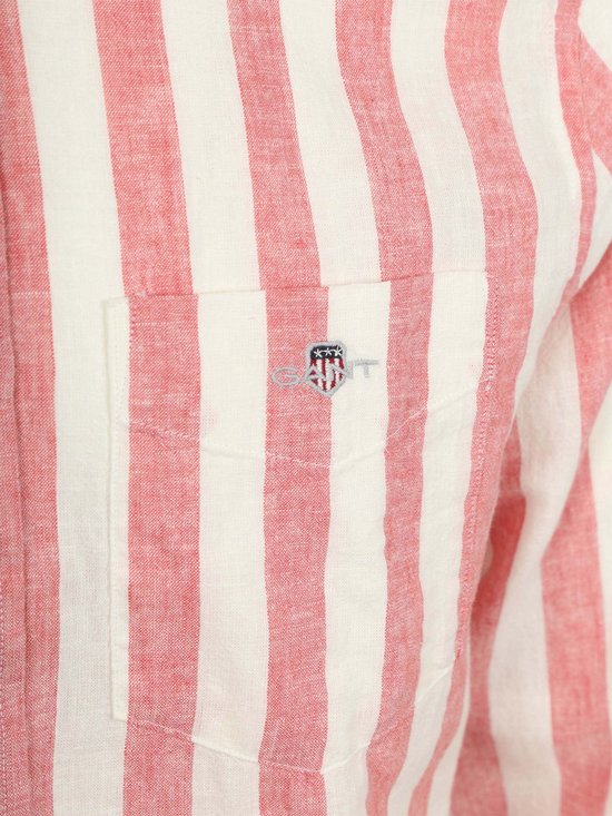 Close-up van de borstzak van een roze en witte gestreepte linnen mix blouse met logo.