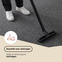 Tapis gris foncé aspiré, montrant un aspirateur.