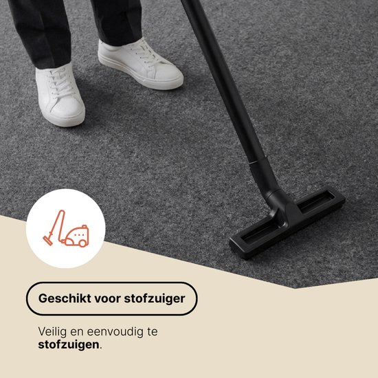 Tapis gris foncé aspiré, montrant un aspirateur.