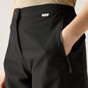 Close-up van een zwarte, waterdichte outdoorbroek voor dames, met een ritszak aan de zijkant.