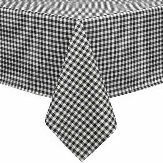 Zwart-wit geblokt tafelkleed dat over een tafel hangt.