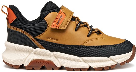 Bruine sneaker met zwarte en oranje accenten, oranje lus en klittenbandsluiting.