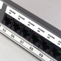 Dichtbij van een patchpaneel met genummerde poorten, van 65 tot 70, met de tekst 'PHONE' erboven.