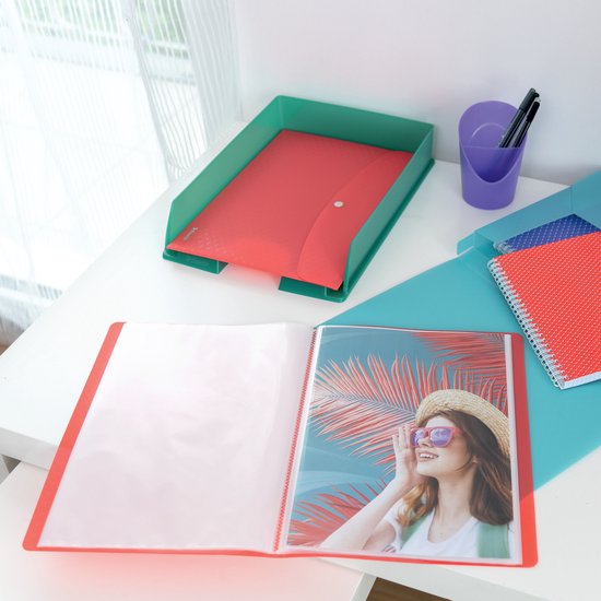 Bureau met mappen, notitieboekjes, pennen en een foto van een vrouw met hoed en zonnebril.