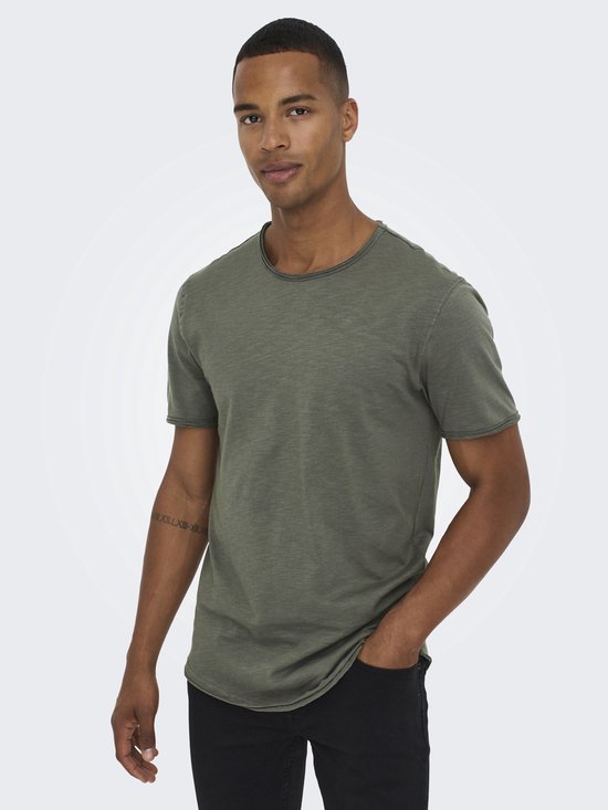 Model draagt een groene T-shirt met ronde nek en korte mouwen vanONLY & SONS, met de hand in de zak.
