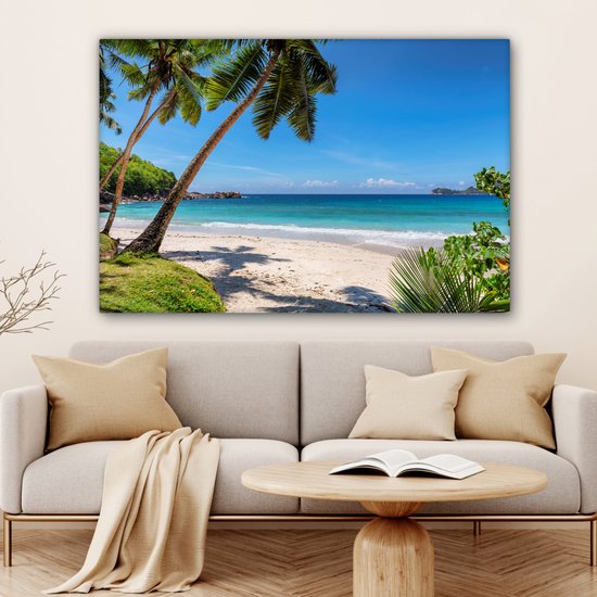 Une plage tropicale avec du sable blanc, des palmiers et une mer d'azur.