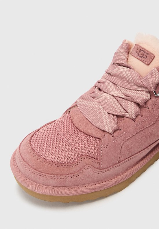 Roze UGG sneaker met suède en mesh details, veters en faux fur voering.