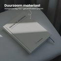 Crèmekleurig 'Growth Journal' op een stoel met zonlicht.