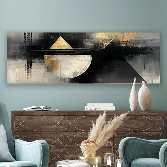 Abstract schilderij met geometrische vormen in zwart, wit en goud, hangend boven een donker houten dressoir.