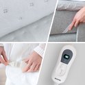 Collage: detail van witte stof met stippen, een hand die een witte kabel in een witte connector steekt, een hand die elastiek om een matras legt, en een witte controller met grijze details.
