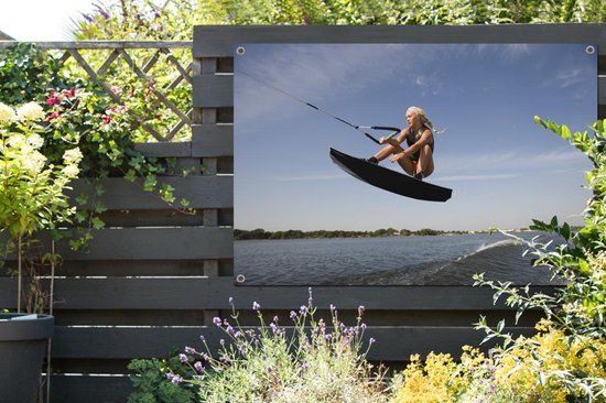 Une femme sportive s'agenouille sur un poster de jardin wakeboard 180x120 cm - Toile de jardin / Toile d'extérieur / Peintures d'extérieur (décoration de jardin) XXL / Groot format!