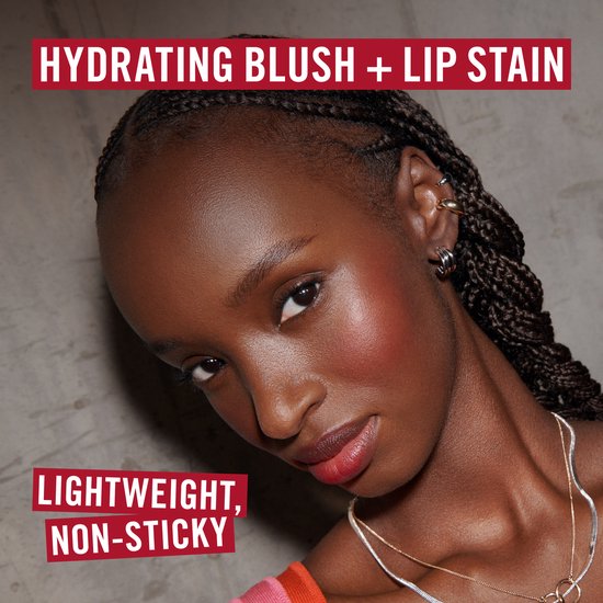 Vrouw met donkere huid en vlechten draagt de blush op haar wangen. Tekst: 'HYDRATING BLUSH + LIP STAIN. LIGHTWEIGHT, NON-STICKY.'