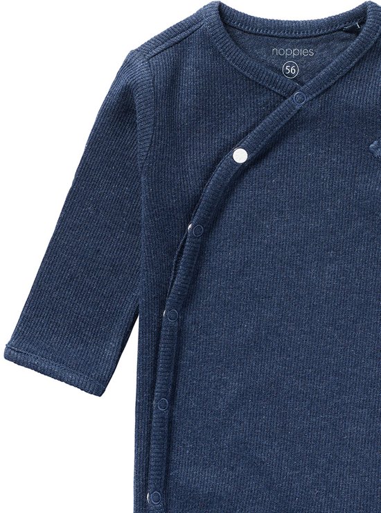 Detail van een donkerblauw geribbeld boxpak met overslagsluiting en drukknoopjes.