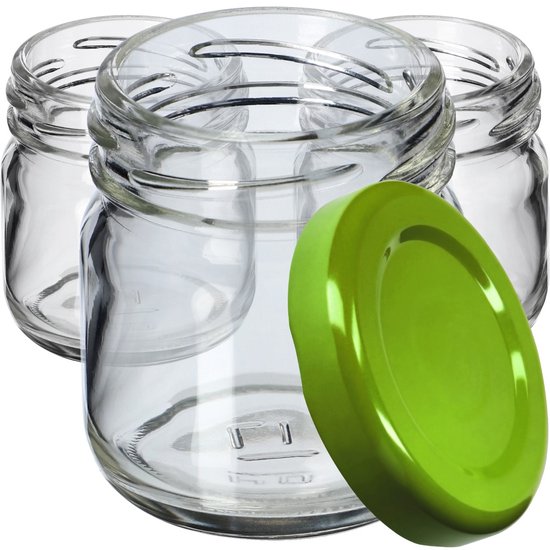 Drie kleine glazen potjes, op de voorgrond een glanzend groen deksel.