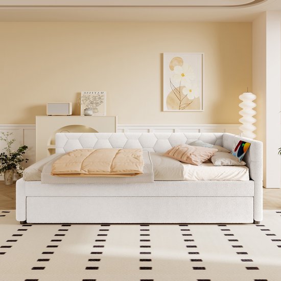 Witte slaapbank met uitschuifbaar bed, hexagonaal patroon op de rugleuning en zachte plaids.