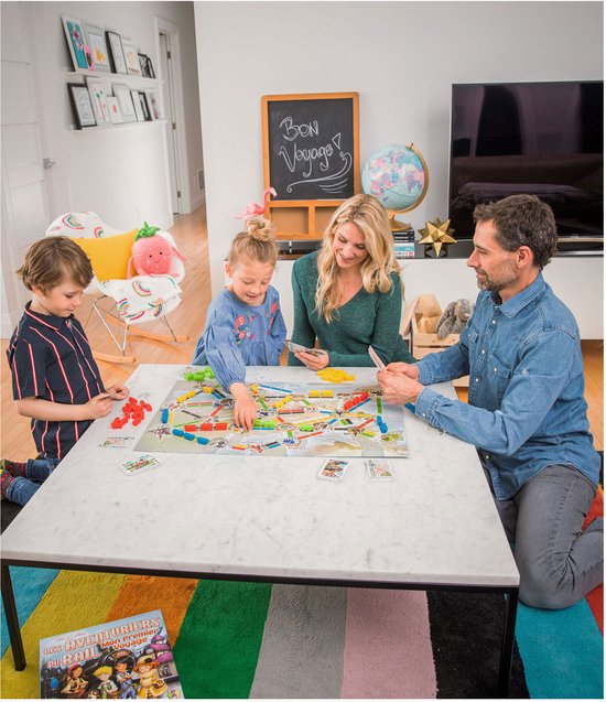 Gezin speelt Ticket to Ride: Mijn Eerste Reis. Kinderen en ouders aan tafel met speelbord en kaarten.