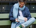 Man met blauwe sjaal en bril houdt een lichtgrijze Mepal bento lunchbox vast.