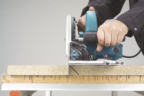 Makita invalcirkelzaag die een plaat zaagt, geplaatst op een houten constructie. De zaag is ingesteld op 22.5V.