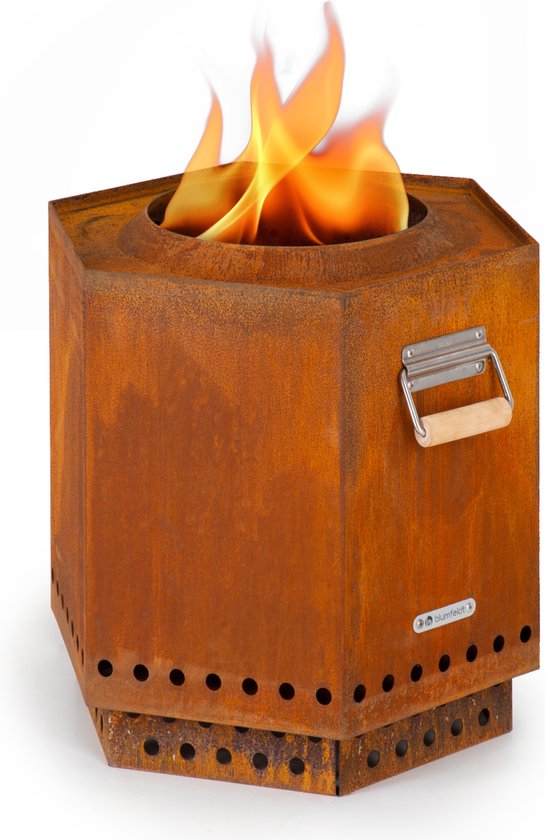 Roestbruine, zeshoekige vuurschaal van staal met brandend vuur, geperforeerde rand en houten handgrepen.