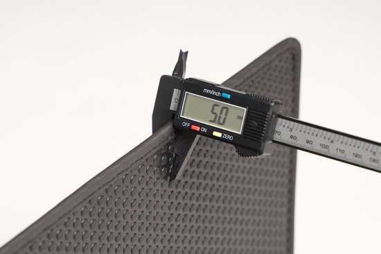 Digitale schuifmaat meet de dikte van 5 mm van een zwarte mat met noppenpatroon