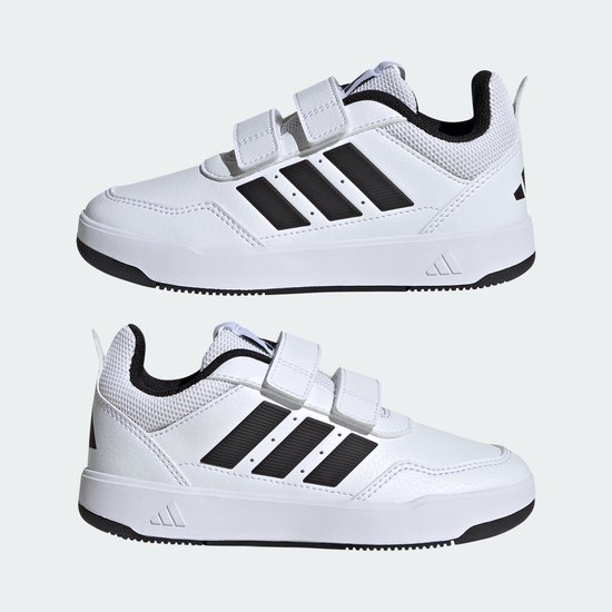 Twee witte Adidas sneakers met klittenbandsluiting, zwarte strepen en zwarte zolen.