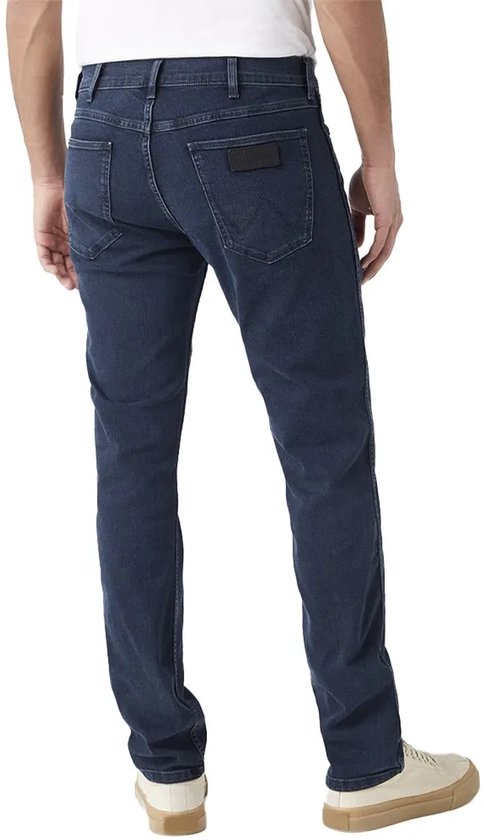 Man die een donkerblauwe Wrangler-spijkerbroek draagt, van achteren gezien.
