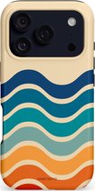 Telefoonhoes met retro golfpatroon in crème, oranje, blauw en groen. De achterkant met cameralens is zichtbaar.