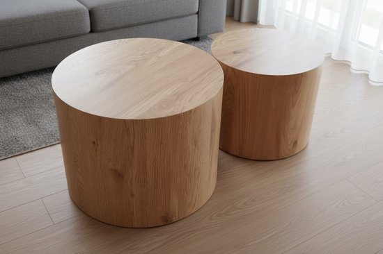 Deux tables d'appoint rondes en bois avec un grain de bois clair, dans un salon.