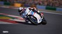 Motorcoureur in wit-rood pak op een witte motor met Britse vlag.