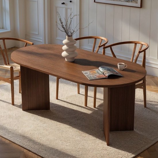 Ovale eettafel van donker hout met vier houten stoelen.