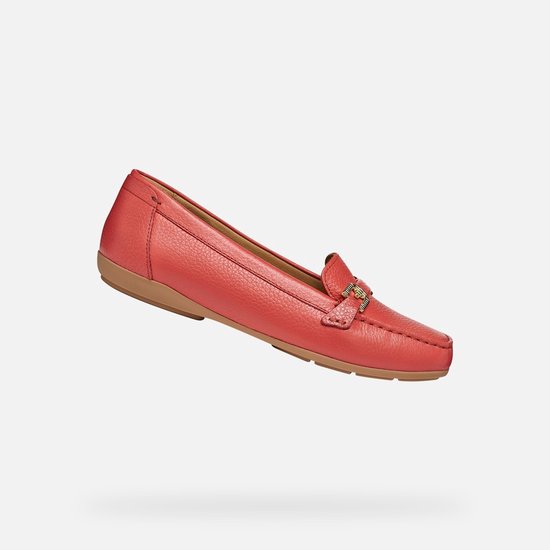 Koraalrode leren loafer met gouden gesp en een bruine zool, zwevend.