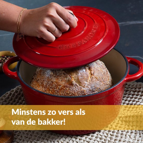 Hand tilt deksel van rode gietijzeren pan met brood erin. Minstens zo vers als van de bakker!