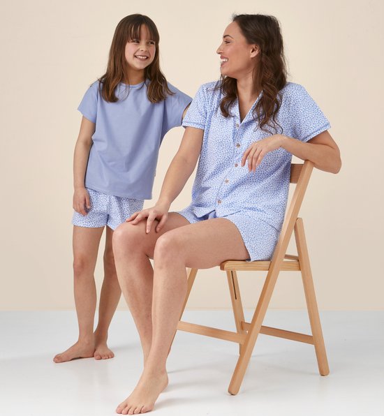 Vrouw en meisje in bijpassende blauwe pyjama's met luipaardprint.