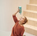 Une fille regarde une gourde bleu clair qu'elle tient à la main.