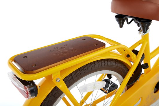 Houten zitting op het achterrek van een gele kinderfiets, met spaken en achterlicht.