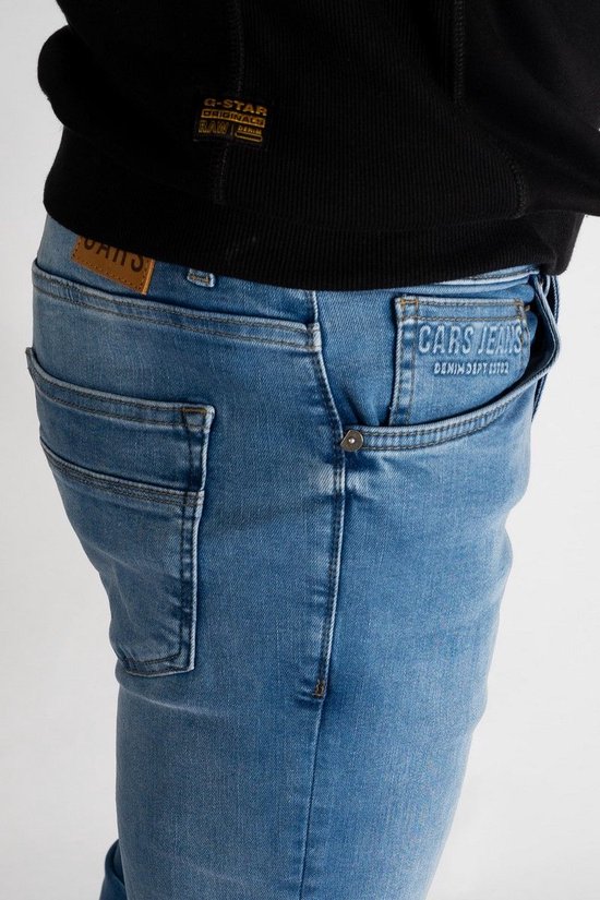 Detail van een spijkerbroek met lichte wassing, riemlussen, zakken en een 'CARS JEANS' label.