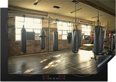 KitchenYeah® Inductie beschermer 75x52 cm - Verschillende bokszakken hangen aan het plafond in een fitnesszaal - Kookplaataccessoires - Afdekplaat voor kookplaat - Inductiebeschermer - Inductiemat - Inductieplaat mat