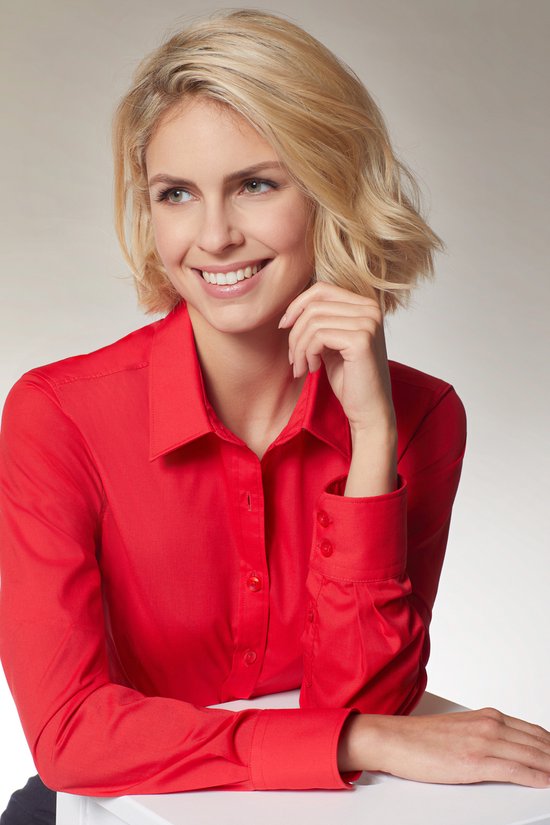 Model met blonde haren draagt een rode blouse met lange mouwen en knoopjes.