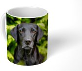 Mok - Koffiemok - Een zwarte Labrador Retriever tussen de groene bladeren - Mokken - 350 ML - Beker - Koffiemokken - Theemok