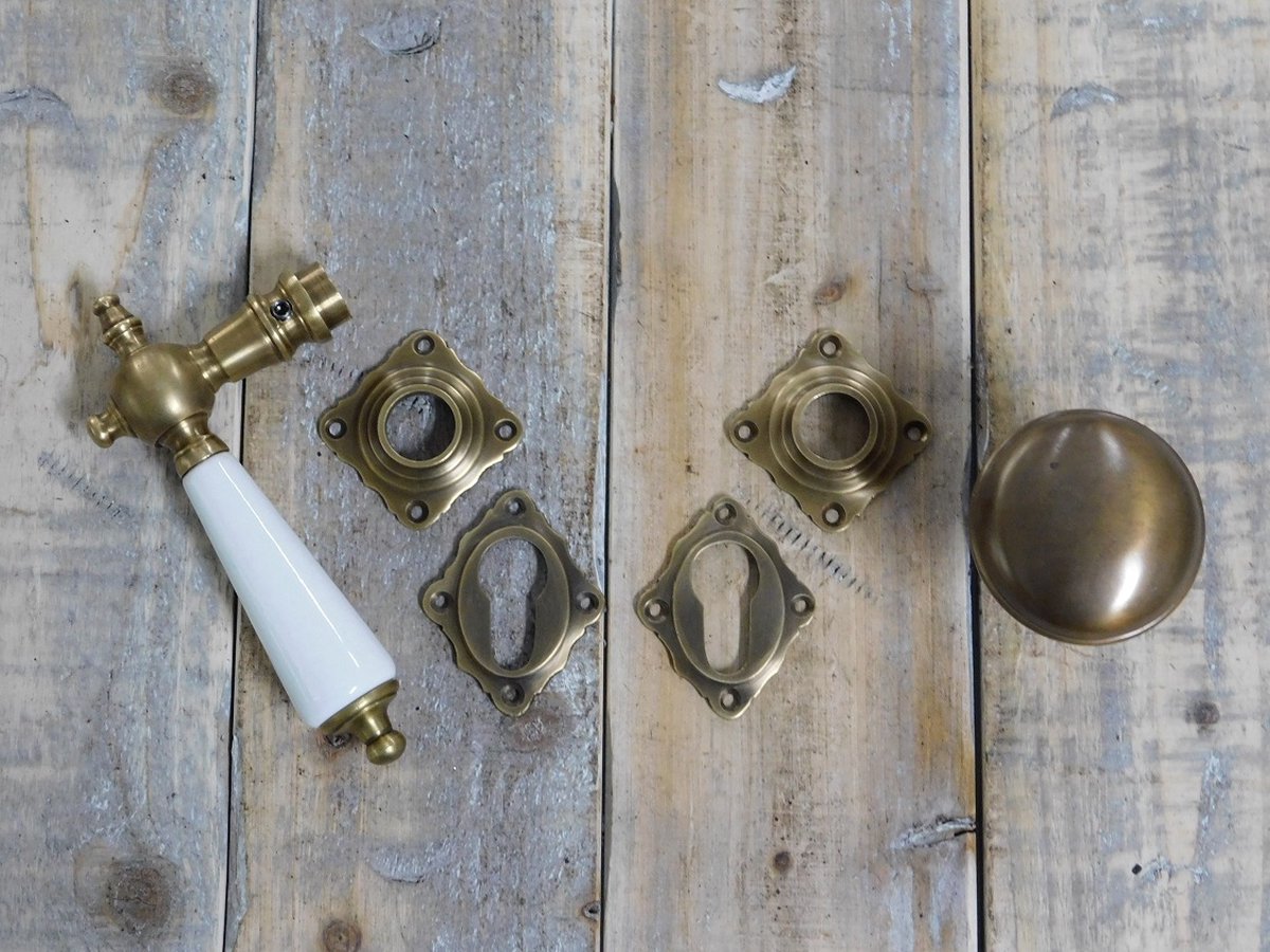Set deurbeslag : 1 knop, 1 deurknop, 4 rozetten, gepatineerd messing met porseleinen ivoorkleurige handvaten, PZ