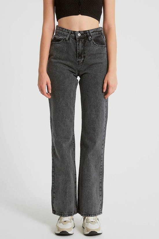 Model in zwarte, high-waist jeans met wijde pijpen.