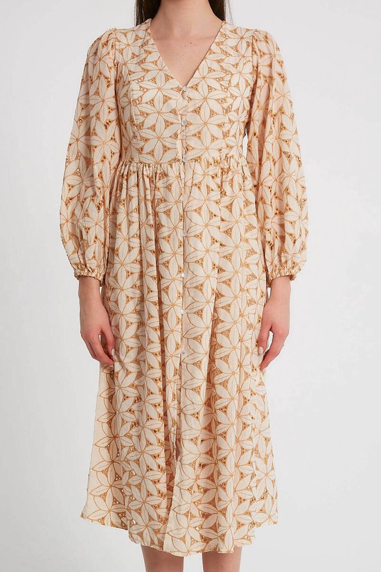 Dames jurk met lange ballonmouwen en een all-over grafische print in camel en crème. De jurk heeft knopen aan de voorkant, een V-hals en valt tot halverwege de kuit.