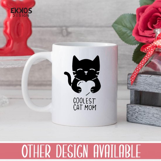 Witte mok met zwarte print van een kat die een hart vasthoudt met de tekst "COOLEST CAT MOM". Rode achtergrond met "OTHER DESIGN AVAILABLE".