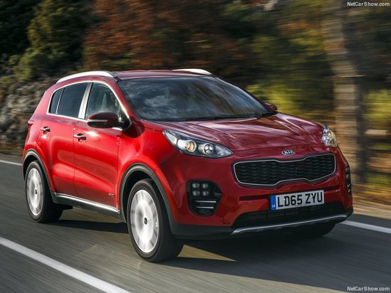 Rode Kia Sportage rijdt op een weg.