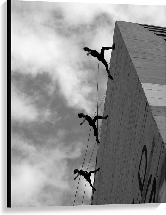 Canvas  - Dansende Mensen tegen Gebouw (zwart/wit) - 75x100cm Foto op Canvas Schilderij (Wanddecoratie op Canvas)