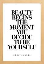 JUNIQE - Poster met houten lijst Beauty Begins - Coco Chanel quote